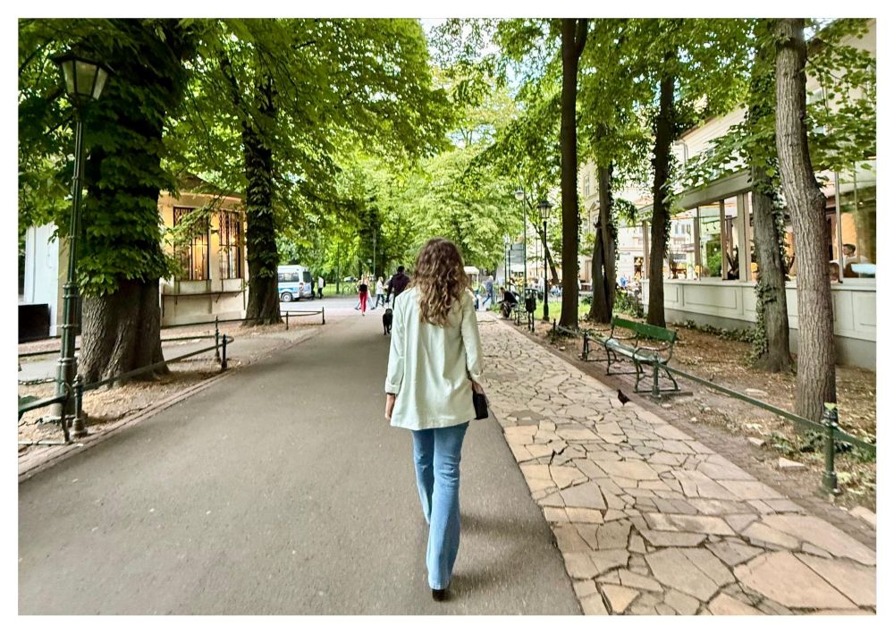 Kobieta idąca alejką Plant w Krakowie – jedno z polecanych miejsc gdzie na spacer w Krakowie.