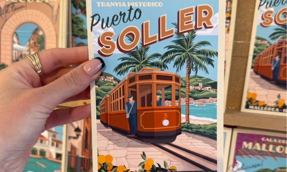 Port de Sóller na Majorce – pocztówka z zabytkowym tramwajem trzymana w dłoni, Majorka plan zwiedzania