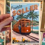 Port de Sóller na Majorce – pocztówka z zabytkowym tramwajem trzymana w dłoni, Majorka plan zwiedzania